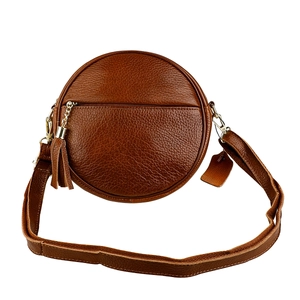Detail of round dark brown leather crossbody bag featuring tassel and gold metal hardware