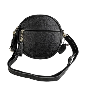 Close-up of black pebble leather round crossbody bag featuring gold zipper and tassel