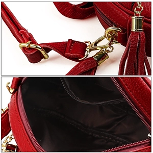 Detail of red pebbled leather shoulder bag showing gold hardware and tassel ornament