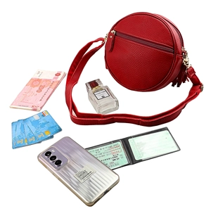 Red round leather crossbody bag with tassel detail and adjustable strap for women
