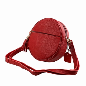 Red circular crossbody bag in litchi grain cowhide leather with elegant gold tassels