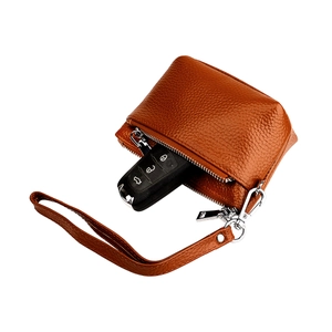 Détail d'un étui à clés en cuir grainé marron avec clé de voiture et fermeture éclair