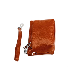 Détail du porte-monnaie en cuir orange grainé avec fermetures éclair et dragonne amovible
