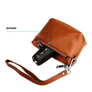 Détail du portefeuille en cuir grainé marron avec poche zippée et crochet en métal argenté