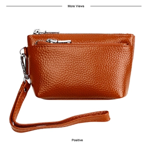 Détail du porte-monnaie en cuir marron grainé avec double fermeture éclair et dragonne