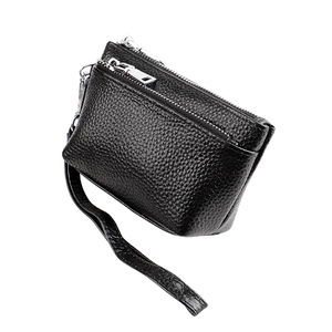 Détail du porte-monnaie en cuir grainé noir avec double fermeture éclair et dragonne