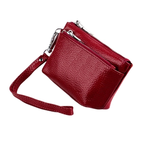 Détail du porte-monnaie rouge en cuir grainé avec double fermeture et dragonne