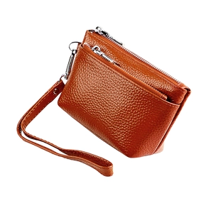 Gros plan du porte-monnaie en cuir marron grainé avec double fermeture et dragonne