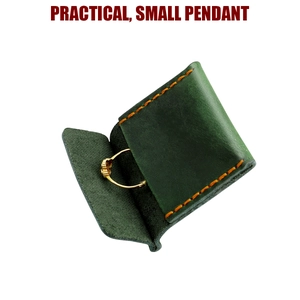 Dettaglio macro di un astuccio per anelli in pelle verde scuro con cuciture vintage e anello