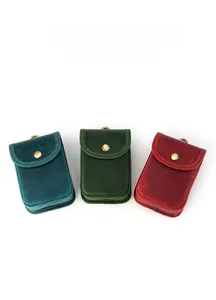 Close-up of retro leather key pouches in blue, green and red with vintage metal snaps