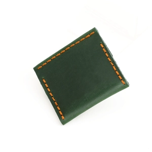 Dettaglio del sacchetto portagioie in pelle verde scuro con cuciture arancioni