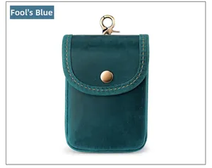 Detail of teal blue crazy horse leather pouch with vintage brass button and metal clip