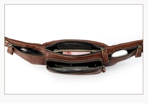 Macro view of leather waist bag showing five zippered pockets and large storage capacity