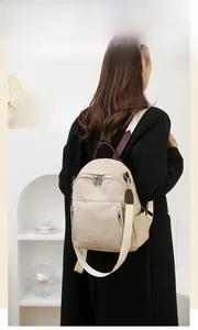 Details des beigen Kunstleder-Rucksacks mit weicher Textur und vertikaler Tasche