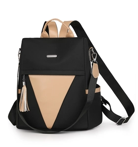 Close-up of contrast nylon backpack with triangle panel and white tassel pendant detail