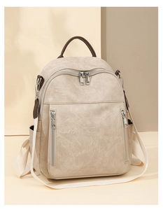 Detailansicht des cremefarbenen PU-Lederrucksacks mit Vintage-Textur und Silberzippern
