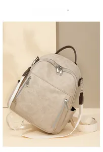 Detailansicht der cremeweißen Leder-Rucksack mit Silber-Zippern und gewebtem Tragegurt