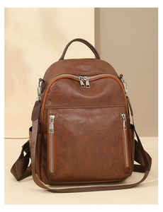 Detailansicht der braunen Kunstledertasche mit vertikalen Metallreißverschlüssen