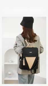 Modern black nylon backpack with beige leather detail shown on a model in a casual setting