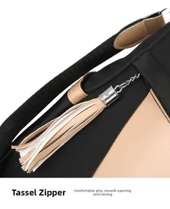 Detail of classic black nylon backpack featuring beige leather trim and long tassel zippers