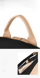 Detail of color-block backpack showing padded leather handle and tassel zipper puller