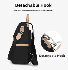 Detail of detachable shoulder strap with silver hooks on black nylon travel backpack