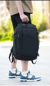 Detail of a black tactical backpack with reinforced handle and multi-layer zipper system