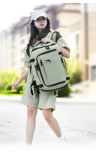 Outdoor mint green backpack with multiple zipper pockets and side buckles shown on model