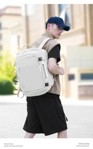 Outdoor view of white minimalist travel backpack with multiple compartments and side handles
