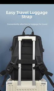 Detalle de mochila para portátil con correa de equipaje fijada al asa de una maleta