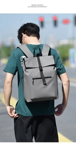 Outdoor shot of a grey waterproof commuter backpack featuring a foldover buckle closure