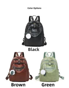 Three-color display of soft leather backpacks in black, brown, and green with pompom charms