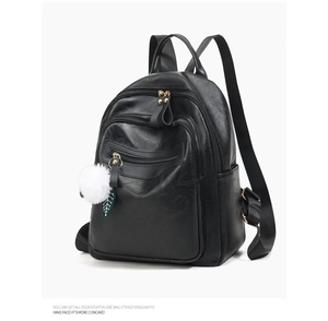 Detail view of black soft PU leather backpack with multiple zip compartments and fluffy charm