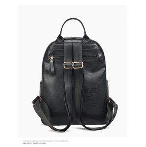 Rear view of black pebble leather backpack with adjustable straps and gold-tone zipper pocket
