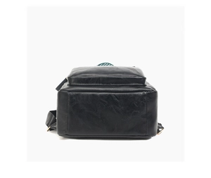 Detail view of the flat wide bottom and lychee pattern leather texture on a black backpack