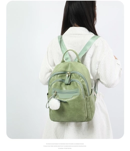 Detail of green soft faux leather backpack with plush pendant on adjustable straps