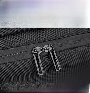 Macro detail of high-quality smooth dual metal zippers on black expandable business backpack