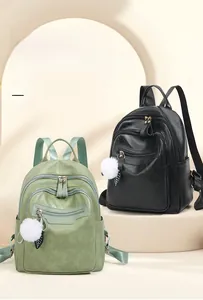 Detailed view of fashionable leather backpacks with multi-layer zippers and plush charms