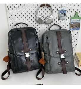Detail of vintage PU leather backpacks with metal buckles and teddy bear plush charms