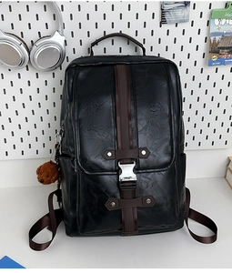 Detail of black PU leather backpack featuring brown straps and silver metal buckles