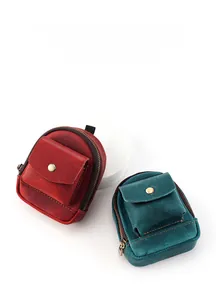Macro detail of two vintage cowhide mini key pouches in red-brown and teal leather