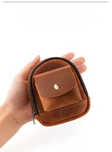 Handheld view of brown leather waist bag showing compact size and dual storage pouches