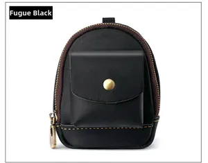 Detailed close-up of the vintage black leather mini pouch with bronze metal snap button