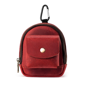 Close-up of vintage red leather waist pouch with metal carabiner and snap pocket detail