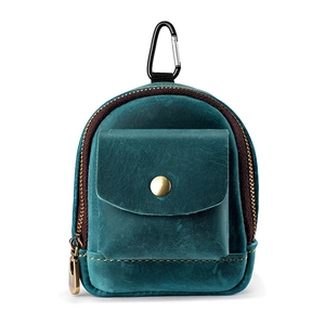 Macro shot of dark teal leather coin pouch with zipper and bronze metallic snap button