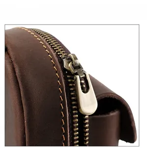 Macro shot of retro brass zipper and precision stitching on premium brown leather pouch