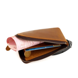 L-shaped zipper opening of a brown crazy horse leather wallet showing internal capacity