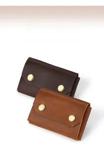 Detail of minimalist leather card holder in brown and tan with double metal snap buttons