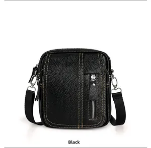 Detailed close-up of men's black pebbled leather crossbody bag with yellow stitching detail