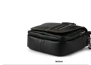 Detail view of black lychee grain leather crossbody bag with orange contrast stitching